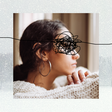 girl sitting in a sweater looking forlorn against snow